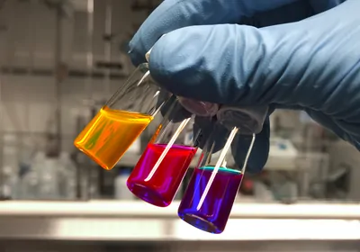 Three luminous liquids in test tubes